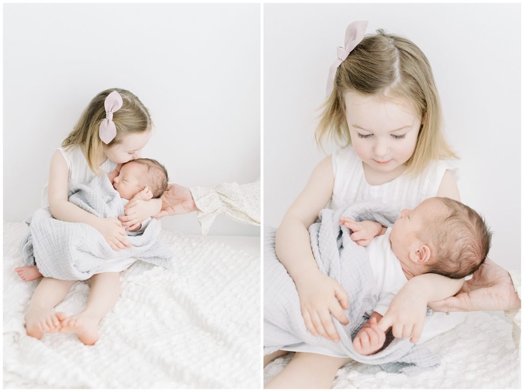 little sister hugging newborn baby brother
