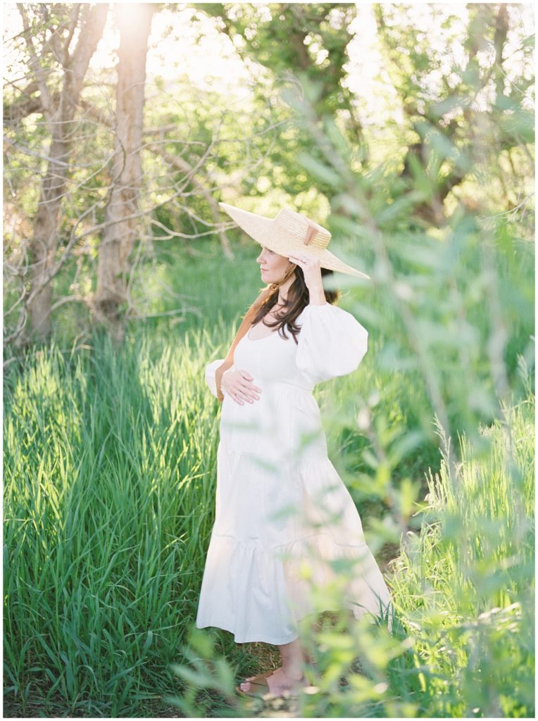 pregnant mother in white dress and straw hat
