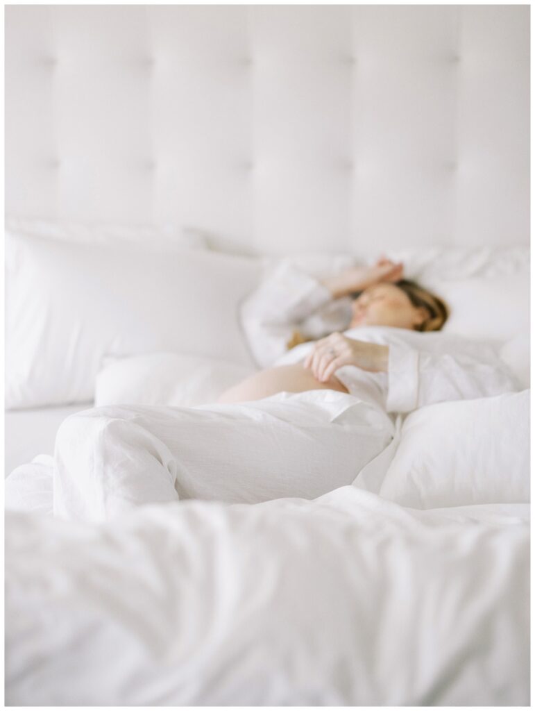pregnant mother in her bed with all white linens
