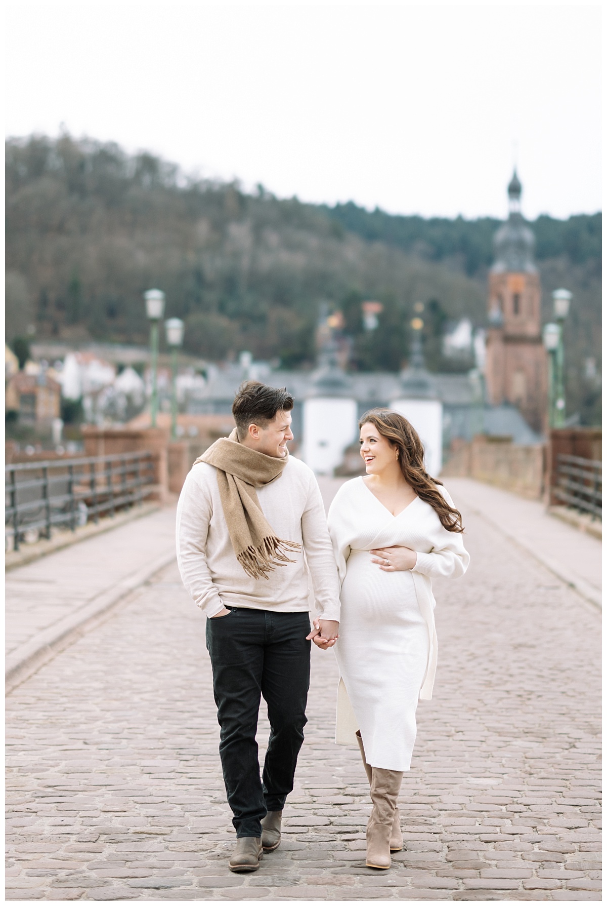 expectant mother and husband on old bridge in heidelberg, germany